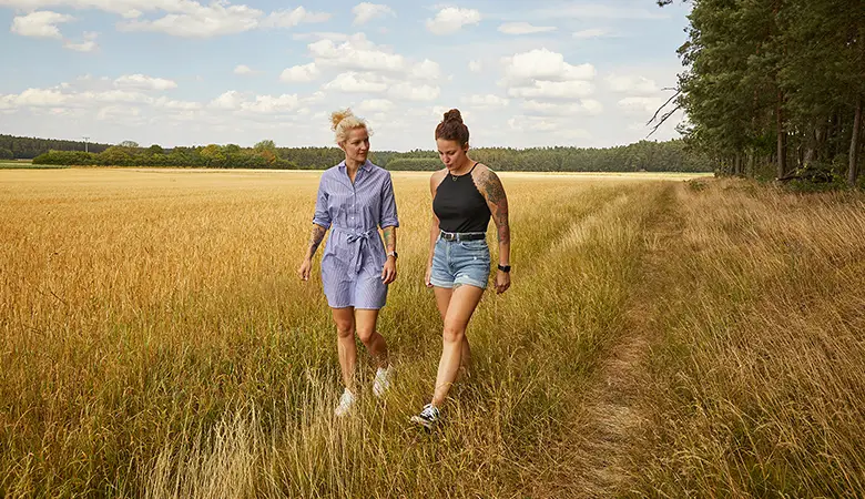 Zwei Frauen laufen über ein Feld. 