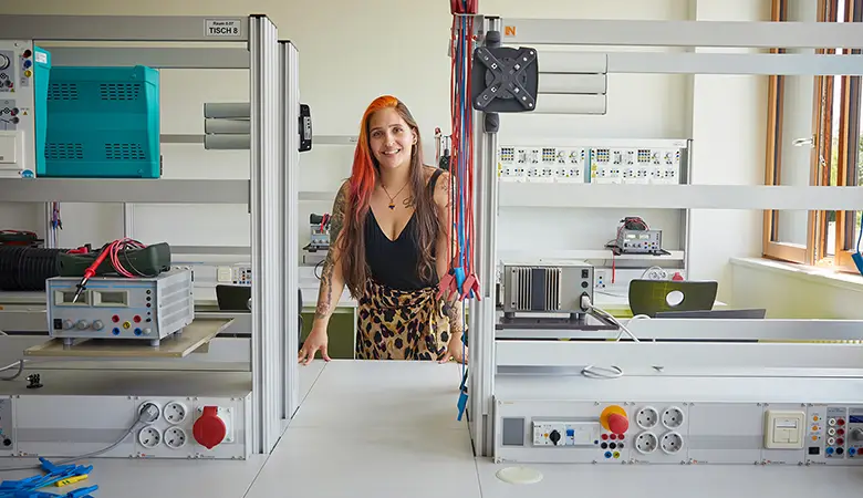 Frau steht hinter einem Arbeitstisch in einem Labor. 